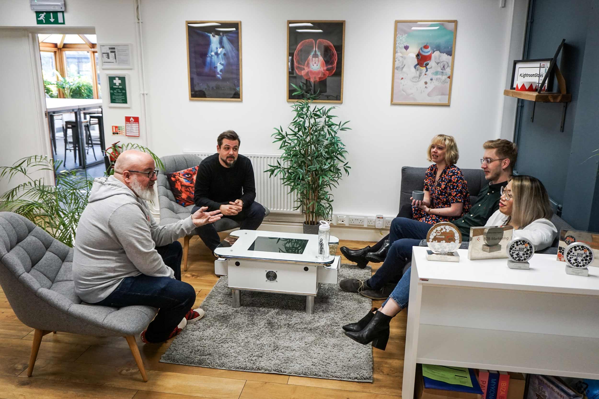 The team conversing in the lounge area of the office.