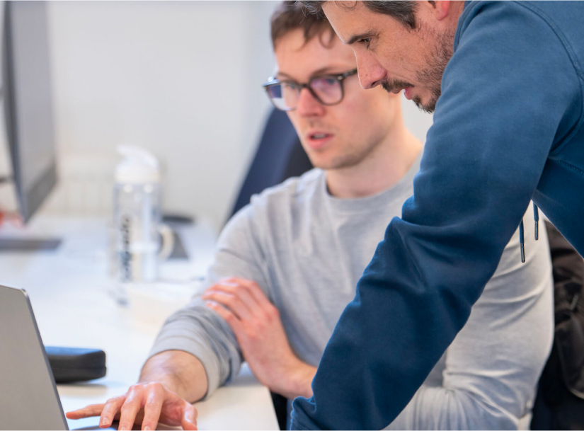 two colleagues looking at a screen and working together as a team